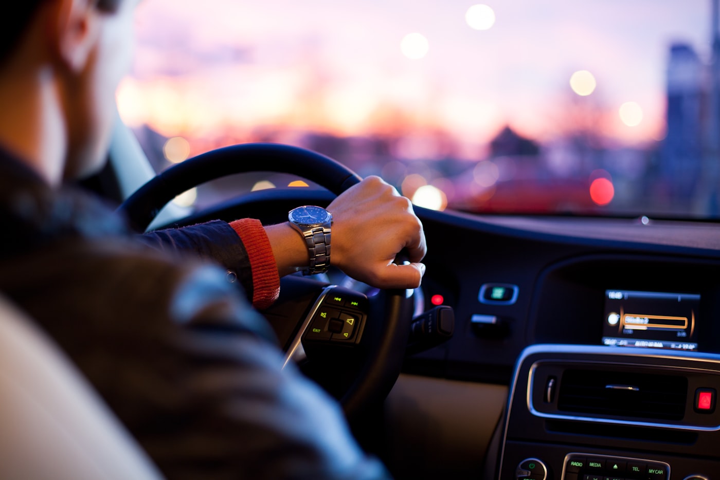 Driving forward at dusk, city lights ahead