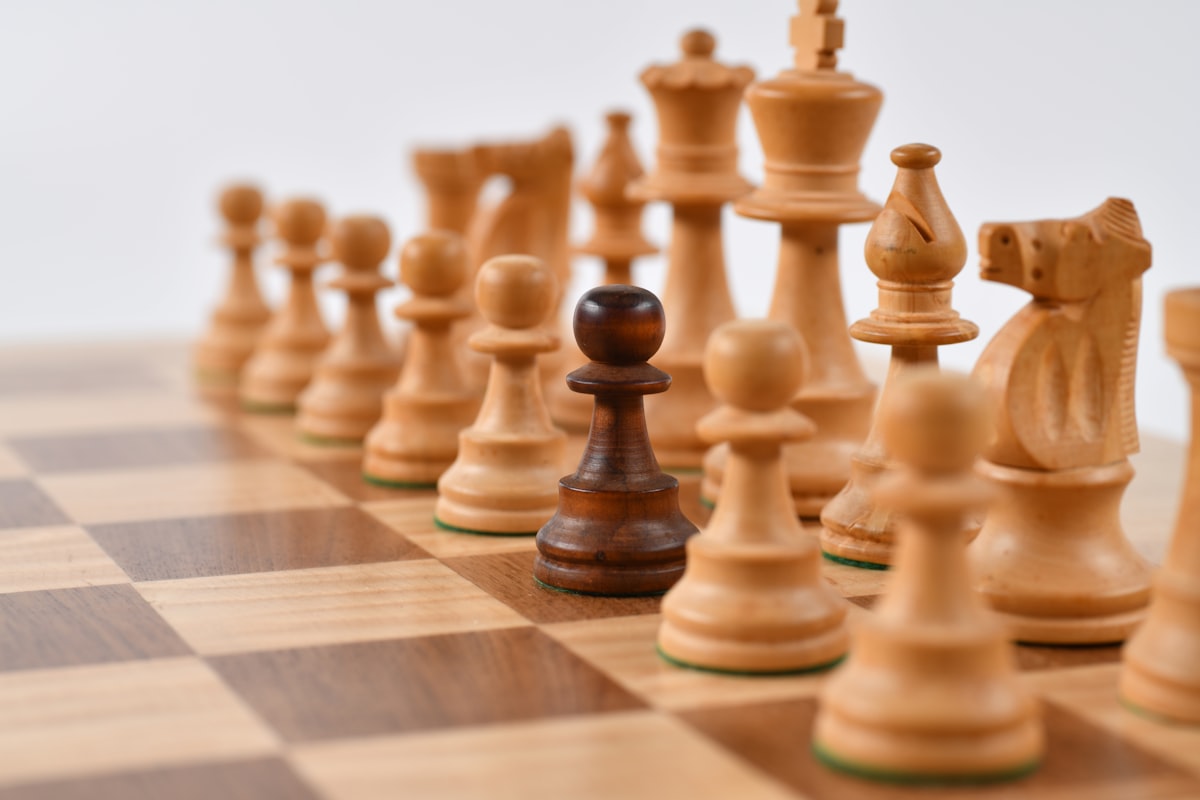 Chess board with one dark pawn among light pieces